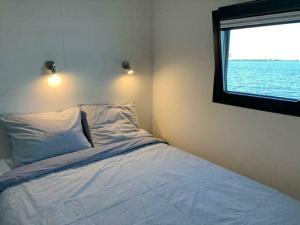 um quarto com uma cama e vista para o oceano em Houseboat - Sneekermeer em Offingawier