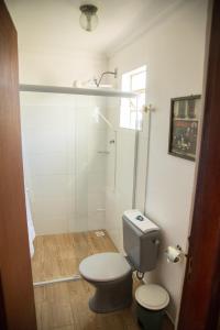 een kleine badkamer met een toilet en een douche bij Pousada Canto Verde in São Bento do Sapucaí