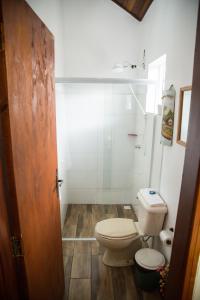 een badkamer met een toilet en een douche bij Pousada Canto Verde in São Bento do Sapucaí