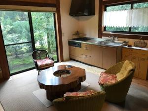 a kitchen with a wooden table and chairs and a table at Wa no Cottage Sen-no-ie in Yakushima