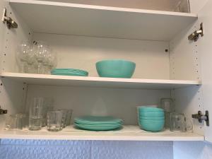 a shelf with blue bowls and other glass items at Appart port du cap d agde in Cap d'Agde +7 photos