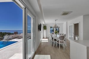 comedor con mesa y vistas al océano en Villa Prestige en Baška Voda