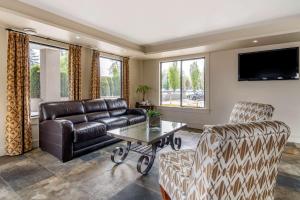 uma sala de estar com um sofá de couro e uma mesa em Econo Lodge Inn & Suites em Kelowna