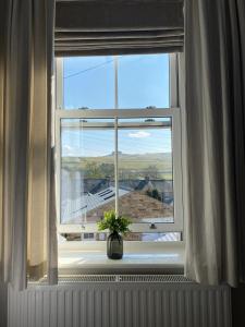 uma janela com um vaso sentado no parapeito da janela em The Hill B&B em Middleton in Teesdale