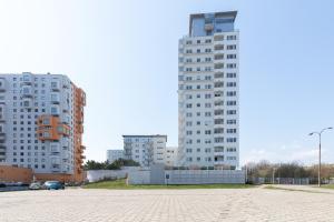 two tall buildings in a city with a parking lot at Marina Primore Apartments by Renters in Gdańsk