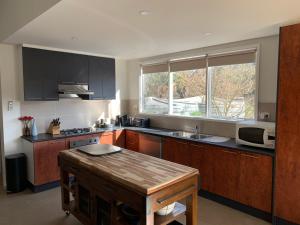 a kitchen with a wooden table and a microwave at Omaroo High Country Retreat in Bonnie Doon