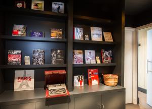 a book shelf with books and a computer on a desk at 1er Etage Marais in Paris