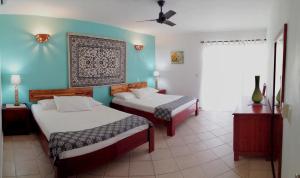 a bedroom with two beds and a blue wall at Dulce Vida Cabarete in Cabarete