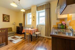 Una cocina con fregadero y una mesa con sillas. en Villa Walir - Spa Hotel Garni SUPERIOR, en Mariánské Lázně
