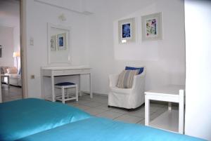 1 dormitorio con cama, escritorio y silla en Villa Fleria Seaside Studios & Apts, en Gerani