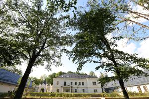 a large white building with trees in front of it at Dvorac Janković in Suhopolje