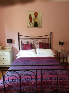 a bedroom with a bed with a purple bedspread at Les Charrons in Ségur-le-Château