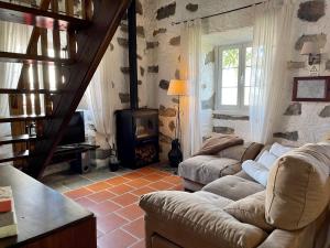 a living room with two couches and a wood stove at Casa de Pilatos in Mosteiros