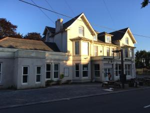 a large white building sitting on the side of a street at Burrator Inn in Yelverton