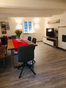 a living room with a dining table and a television at Ferienwohnung Waldblick in Lennestadt
