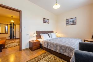 a bedroom with a bed and a living room at Villa Walir - Spa Hotel Garni SUPERIOR in Mariánské Lázně