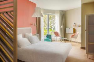 een slaapkamer met een bed en een tafel en stoelen bij OKKO Hotels Lille Centre in Lille