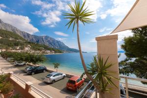 a view of a beach and cars parked on a street at Beach Apartment Estelle in Podgora