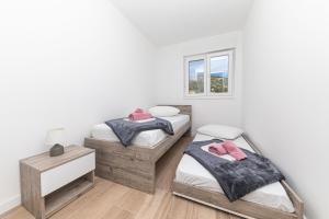 two twin beds in a room with a window at Sea view in Trogir