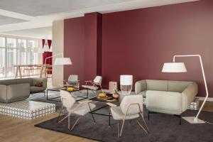 a living room with a couch and a table and chairs at OKKO Hotels Lille Centre in Lille