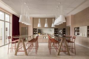 a kitchen with a long dining table and chairs at OKKO Hotels Lille Centre in Lille