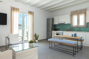 Amperian Mykonos Suites & Villas في مدينة ميكونوس: غرفة معيشة مع طاولة ومطبخ