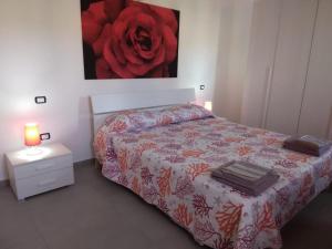 una camera da letto con un letto dipinto a rosa rossa sul muro di Borgo San Giorgio a Àrbatax