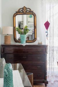 a dresser with a mirror on top of it at Castel Abaso Boutique Apartments by Explore Andros in Andros