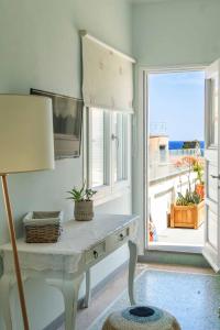 a room with a desk and a window with a view at Castel Abaso Boutique Apartments by Explore Andros in Andros