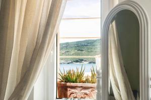 a room with a window with a view of the ocean at Castel Abaso Boutique Apartments by Explore Andros in Andros