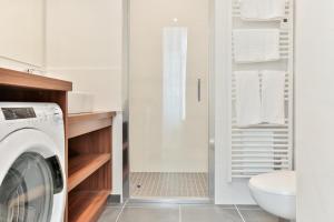 een wasruimte met een wasmachine en droger in de badkamer bij VILLA14 in Dijon