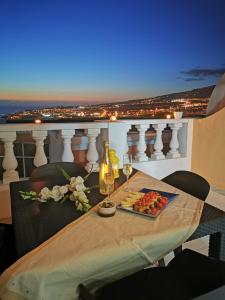 una mesa con un plato de comida y copas de vino en Ocean View Apartment, en Adeje