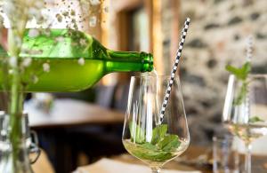 a green bottle is pouring wine into a glass at Der Schumi Landgasthof in Reipersdorf