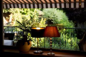 eine Lampe auf einem Tisch vor einem Fenster in der Unterkunft Der Schumi Landgasthof in Reipersdorf