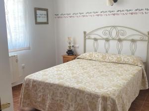 1 dormitorio con 1 cama con colcha blanca en Casa Rural Villa Lucia en Ossa de Montiel