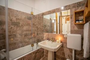 a bathroom with a sink and a tub and a mirror at Apartamento ALIANÇA in Faro