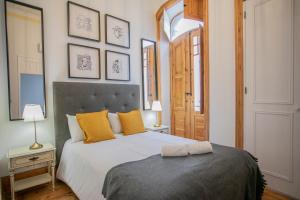 una camera da letto con un grande letto con cuscini gialli di Apartamento ALIANÇA a Faro