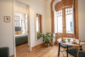 a living room with a table and a room with a bed at Apartamento ALIANÇA in Faro