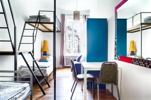 a room with bunk beds and a table and a desk at Old Town Kanonia Hostel & Apartments in Warsaw