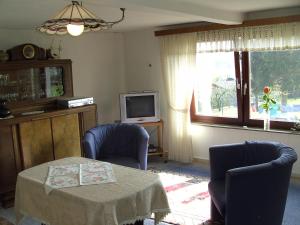 ein Wohnzimmer mit einem Tisch, 2 Stühlen und einem TV in der Unterkunft Ferienwohnung Finkam in Holle