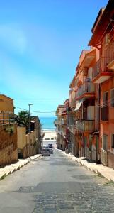 una calle vacía con edificios y el océano en el fondo en Bastione, en Gela