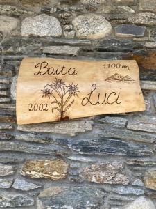een teken aan de zijkant van een stenen muur bij Baita Luci in Gravedona