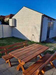 drewniany stół piknikowy przed budynkiem w obiekcie Radosna Zatoka - Domki mobilne i drewniane z ogródkami, apartamenty, namioty w mieście Międzywodzie