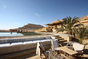 a resort with a pool and chairs and a beach at Talist Siwa in Siwa
