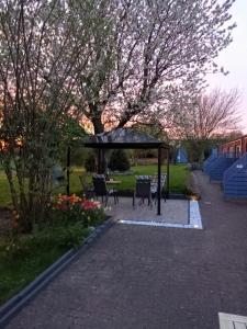 un cenador con sillas y una mesa en un parque en Dat lütte Nest, en Brodersby