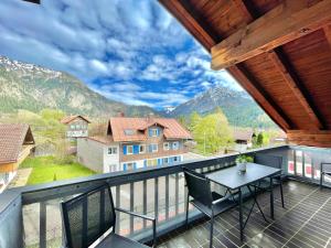 a balcony with a table and chairs and mountains at Hirschbachwinkel - fewo-badhindelang in Bad Hindelang
