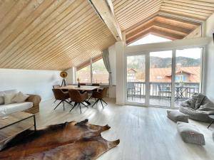 a living room with a wooden ceiling and a table at Hirschbachwinkel - fewo-badhindelang in Bad Hindelang