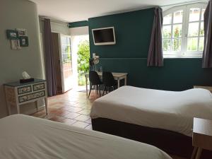 Sérignac-sur-GaronneにあるLogis Hotel Le Prince Noirのベッド2台、テーブルと椅子が備わるホテルルームです。