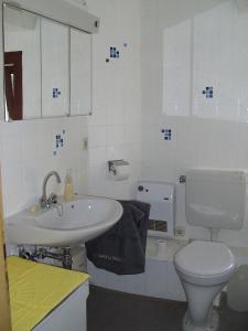 a white bathroom with a toilet and a sink at Ferienwohnung Finkam in Holle