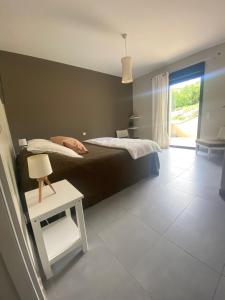 a bedroom with a bed and a table and a chair at Les Centaurines in Saint-Siffret +54 photos